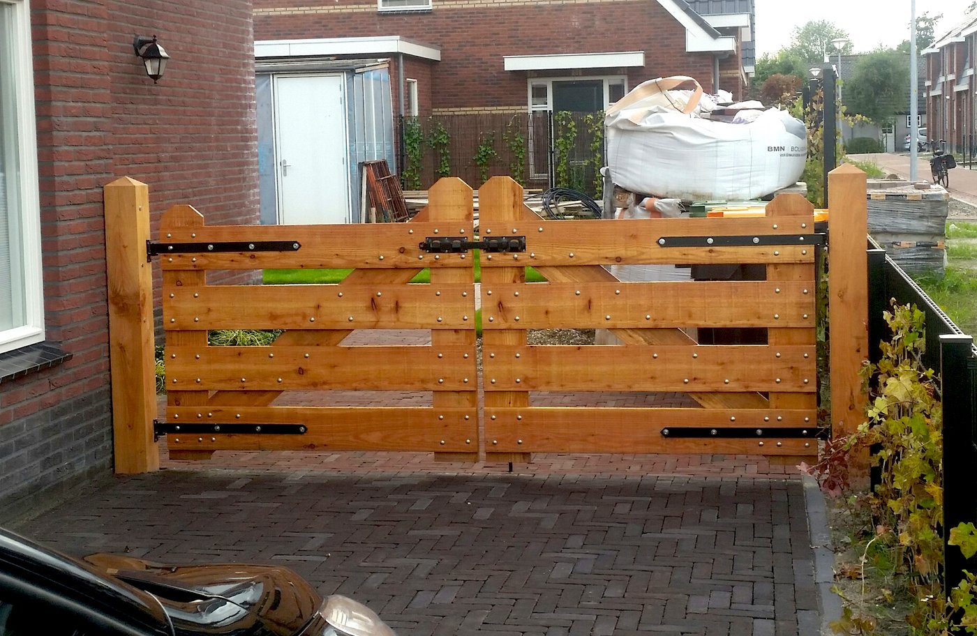 model_luxe_inrijpoort_lariks_douglas_4_planks_houten_poort_oprit_zwart_beslag_sfeer