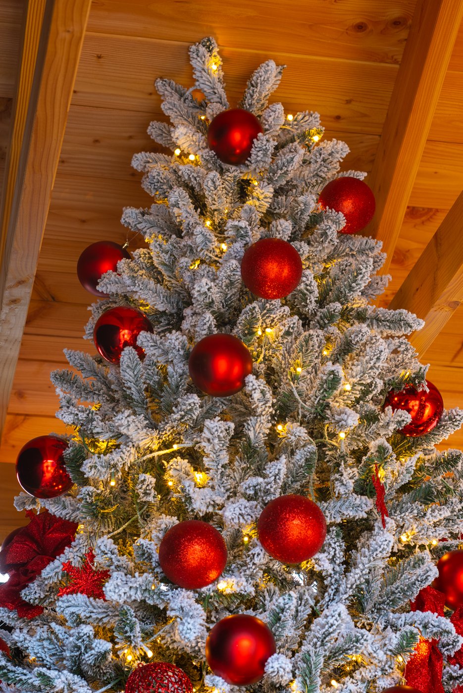 rode_kerstballen_besneeuwde_kunstkerstboom