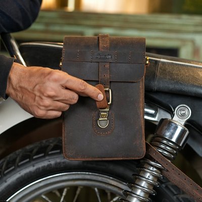 The Trip Machine Moto Sling bag is inspired from the iconic map cases used in WW II. Handcrafted from 2.2 mm thick heavy-duty leather, with a capacity of 1.9 L, the bag is built like a tank, to serve you for decades. It feels at home while on the motorcycle as well as when off it. The versatile quick release mounts allow it to go on every motorcycle and lets you mount or unmount it in under 30 seconds. Perfect for everyday rides, this bag is as dependable, timeless and comes with a rain cover to keep your valuables dry.