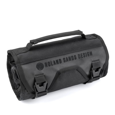 The Roland Sands Design X Kriega Roam Tool Roll is an indispensable piece of kit on any road trip. Store in your luggage or mount to the bike with the Velcro® Molle system, it’s a haven for your tools and spares. Constructed from RSD’s propriety wax cotton together with 1000D Cordura® and super tough hypalon reinforcement, the blend of Classic and Modern materials with a technical twist. Unclip and roll-out to reveal four YKK® zip access pockets, 10 elastic loops and a T6 alloy rail with 8 x 3/8" clips for socket management. Additional 1/4" and 1/2" socket rails can also be added. (sold separately) Available in 2 colour options: black or ranger.
