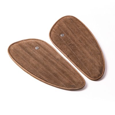 Tobacco brown Suede leather.
Handmade leather fuel tank pad set. Designed to replace standard tank pads or use them in other custom applications to enhance the visual appeal of your bike. Handmade from signature Trip Machine's crunch (extra subtle) genuine leather. These will last well when maintained. Comes with industrial standard 3M tape installed to ensure the tank pads that will not damage your motorcycle paint and stay in place. Sold as a left & right set.
Dimensions: 24cm long x 11cm high x 0.8cm thick.
Note: Old rubber pads can be removed by applying moderate heat so the glue will get soft and the pad can be removed. Take your time. When applying too much heat paint or pads may be damaged. Contact a professional when in doubt.